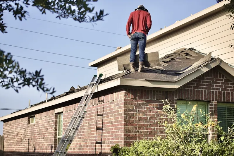 Professional roofer working on a residential roof in Sinton